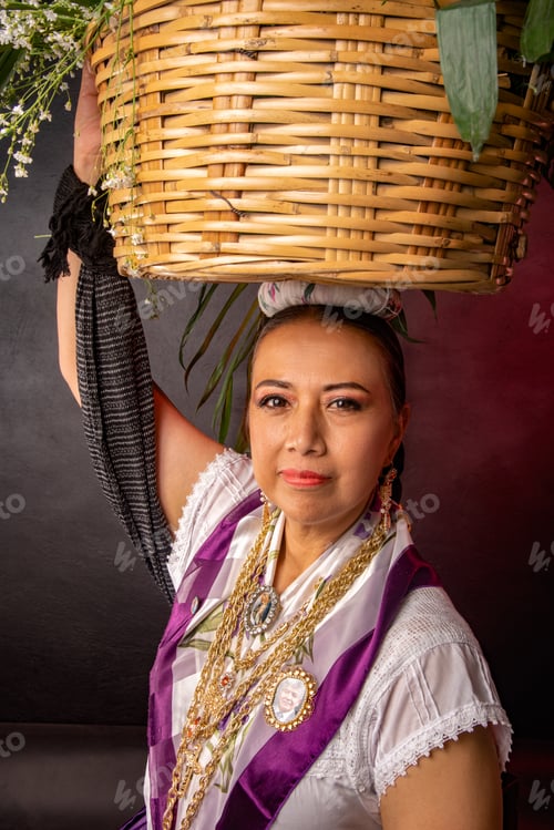 Preview: A woman wearing a purple and white dress is holding a basket on her head