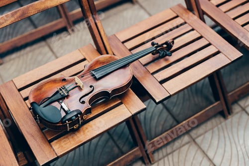Preview: Photo of wooden violin on chairs. Horizontal shot. Live music on special occasion