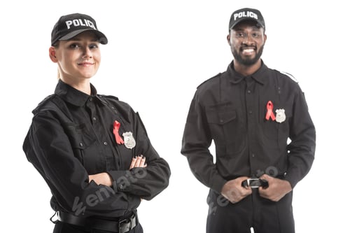 Preview: happy police officers with aids awareness red ribbons looking at camera isolated on white