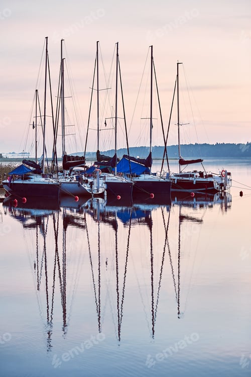 Preview: Yachts and boats moored in a harbour at sunrise. Candid people, real moments, authentic situations