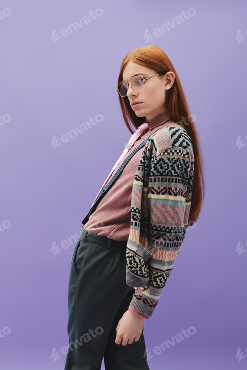 Preview: Stylish young man with long red hair poses confidently against a vibrant purple background