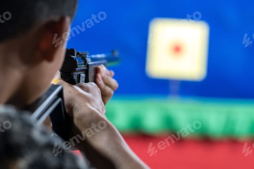 Preview: Rear view of man with his gun on shooting at the target in practice Shooting Range,