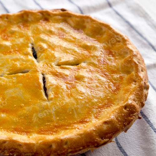 Preview: Delicious Homemade Canadian Tourtiere Meat Pie on cloth, side view.