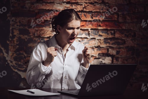 Preview: Angry woman working with laptop at workspace