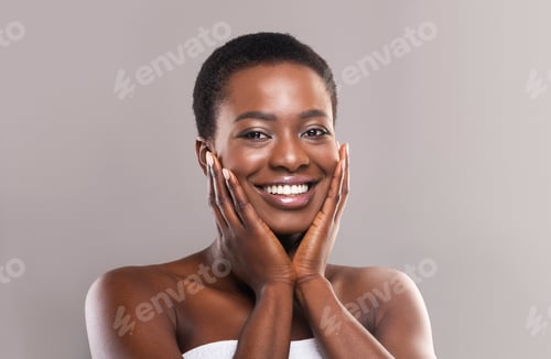 Preview: Smiling Woman Touching Face Against Neutral Background