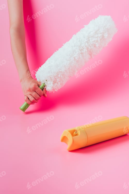 Preview: cropped image of woman holding white duster near spray can, pink background