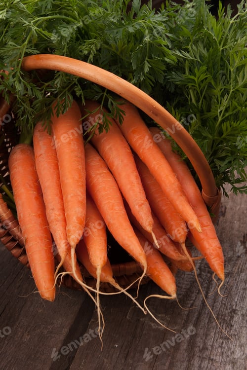 Fresh Carrots in Basket on Wood Table
