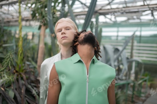 Preview: Man with dreadlocks leaning on shoulder of blonde man