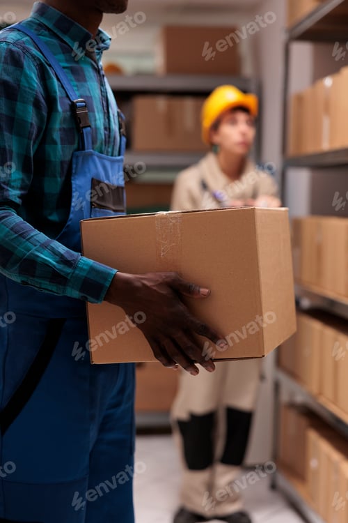 Preview: Man holding customer parcel in mail sorting center warehouse