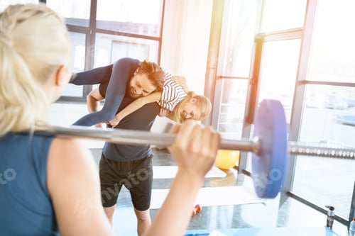 Preview: Woman workout with barbell while man having fun with daughter on his shoulders