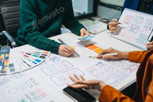 Preview: Close up view of UI developer team brainstorming on their project with laptop, smartphone and tablet