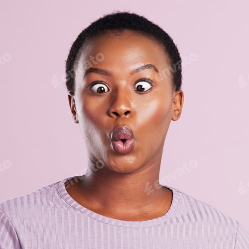 Preview: Studio shot of a young woman making a silly face against a pink background