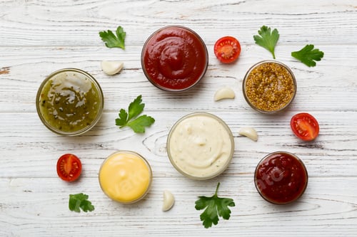 Preview: Many different sauces and herbs on table, flat lay top view. sauces with spices healthy concept
