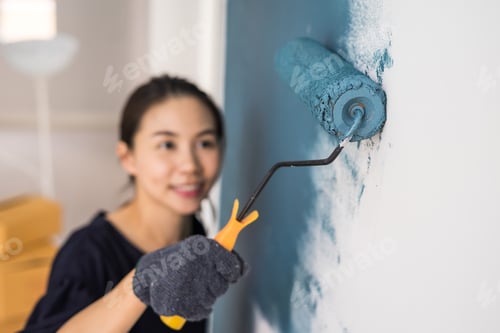 Preview: Young asian happy woman painting interior wal