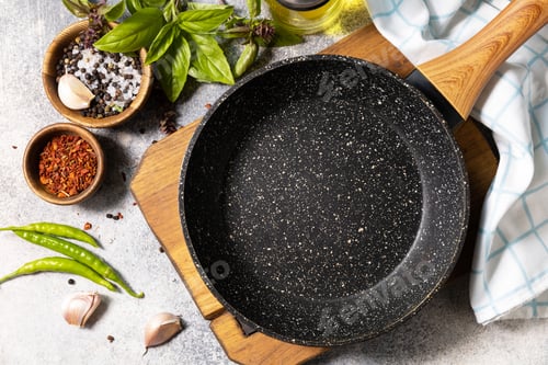 Preview: Empty skillet, vegetables, spices and herbs on gray stone background.