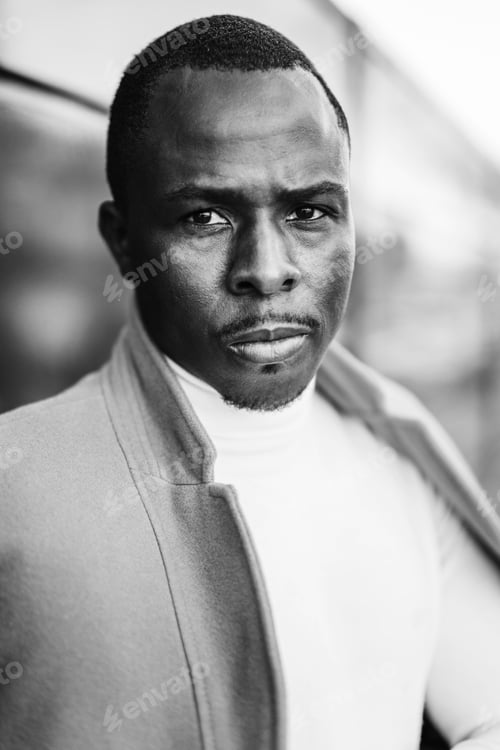 Preview: Grayscale shot of a stylish handsome African male in a coat posing for the camera