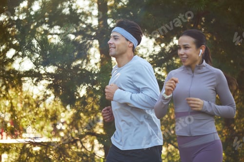 Preview: Young Man and Young Asian Woman Jogging Outdoors Together
