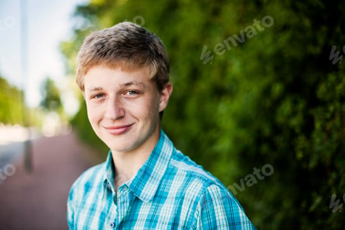 Preview: Portrait of teenage boy smiling on sidewalk