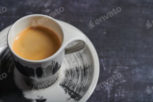 Preview: Closeup shot of a cup of espresso on a black surface