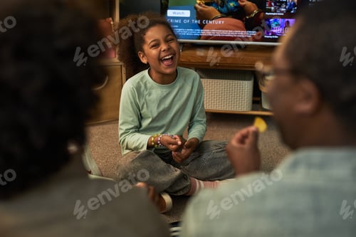 Preview: Preteen Black Girl Laughing While Sitting Indoors with Family Members