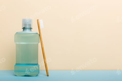 Preview: Mouthwash and other oral hygiene products on colored table top view with copy space. Flat lay.