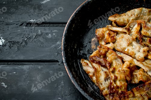 Preview: Fried bacon in a frying pan.
