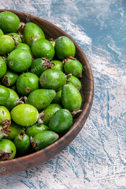Preview: Half shot of delicious vitamin bomb fresh feijoas in a brown pot on the right side of ice