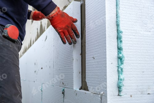 Preview: Construction worker installing styrofoam insulation sheets