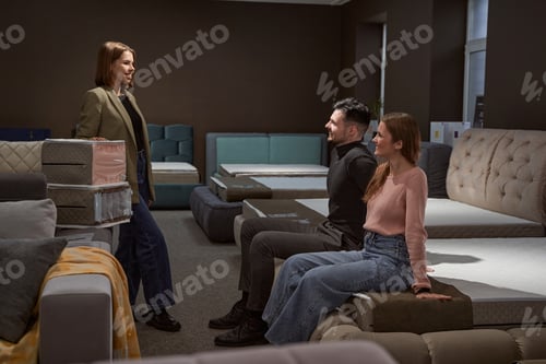 Preview: Customers testing mattress firmness in furniture store