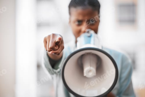 Preview: Shot of a young woman screaming into a loud speaker while protesting in the city