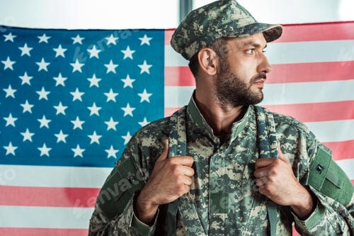 Preview: portrait of soldier in military uniform looking away against american flag