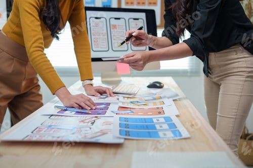 Preview: Two female ux ui designers are discussing mobile app templates, working together to enhance user exp