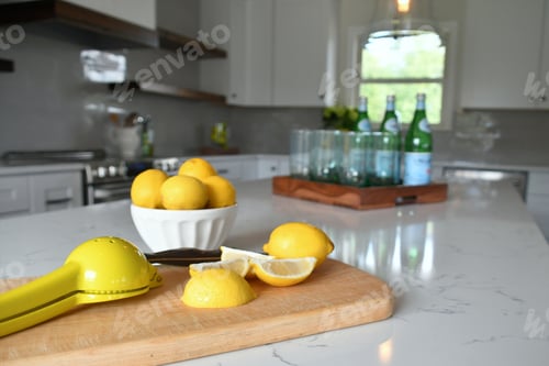 Preview: Bright yellow lemons on the counter of airy, sunny kitchen with accessories in an open concept home
