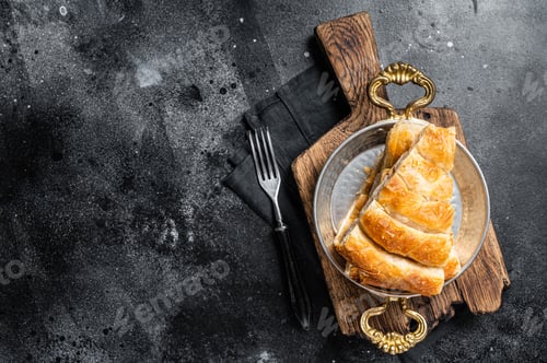Preview: Traditional feta cheese phyllo pastry pie in rustic skillet. Black background. Top view. Copy space