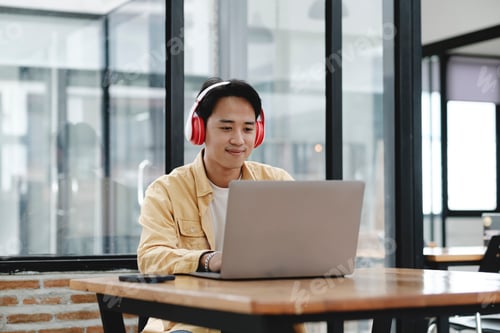 Preview: Young collage student using computer and mobile device studying online.