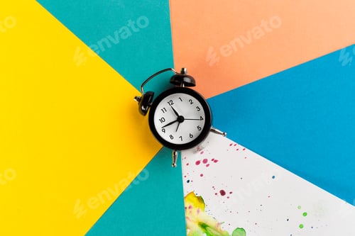 Preview: Vintage alarm clock on a creative colorful background with paint sprinkles