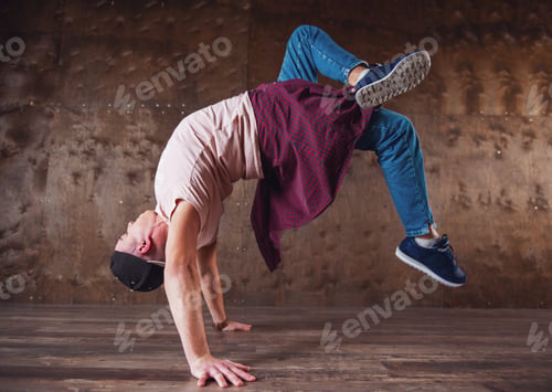 Young man doing gymnastics stunt indoors on hands