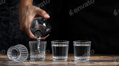 Preview: Barman pouring tequila into four shots