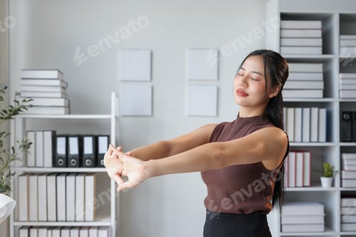 Preview: Young businesswoman is taking a break from work to stretch her arms