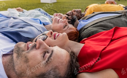 Preview: Diverse Business Team Relaxing Together on Grass During Outdoor Break
