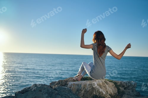 Preview: woman on vacation in the mountains near the sea gestures with her hands and sunset summer