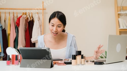 Preview: Happy beautiful young Asian woman use cosmetics review make up tutorial broadcast live video.