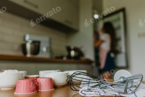 Preview: Variety of cupcake liners in different colors with a muffin pan and wire whisk