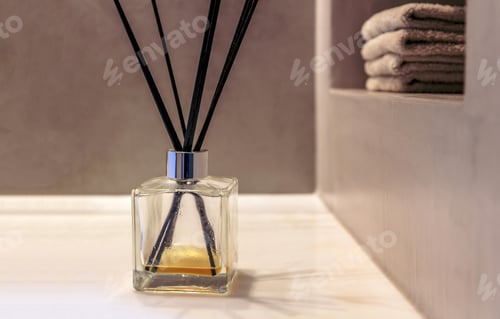 Preview: Reed diffuser in a bathroom, black sticks in a glass bottle, modern design spa interior detail.