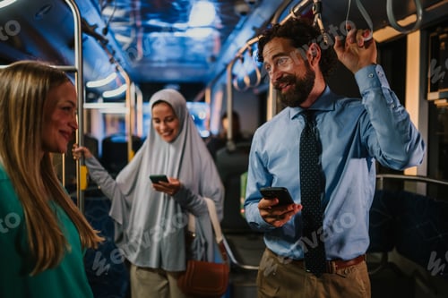 Preview: Multi ethnic commuters using smartphones on a bus at night
