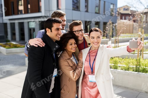 Preview: happy people with conference badges taking selfie