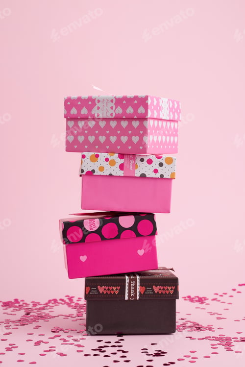 Preview: Stack of cardboard square gift boxes on a pink background