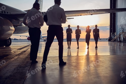 Preview: Two men with four women in uniform isolated on sun background