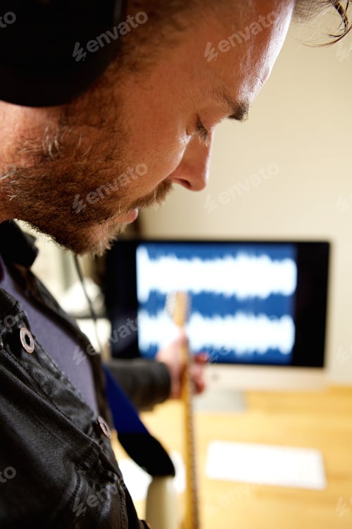 Preview: Male artist recording electric guitar in home studio