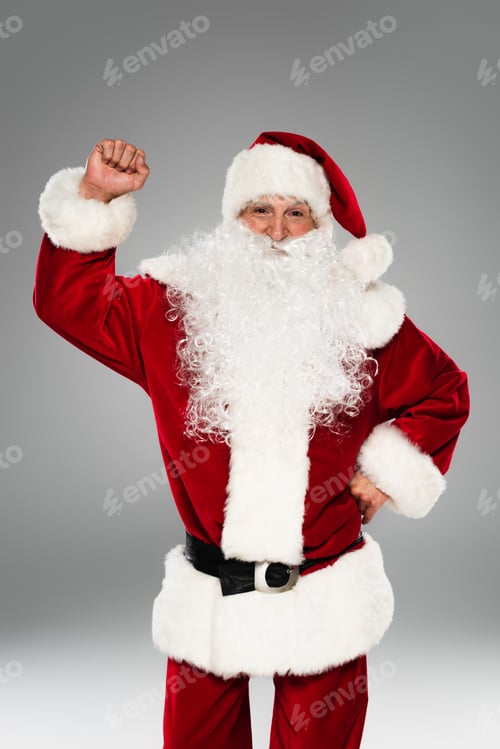 Preview: Bearded santa claus showing yes gesture and looking at camera isolated on grey